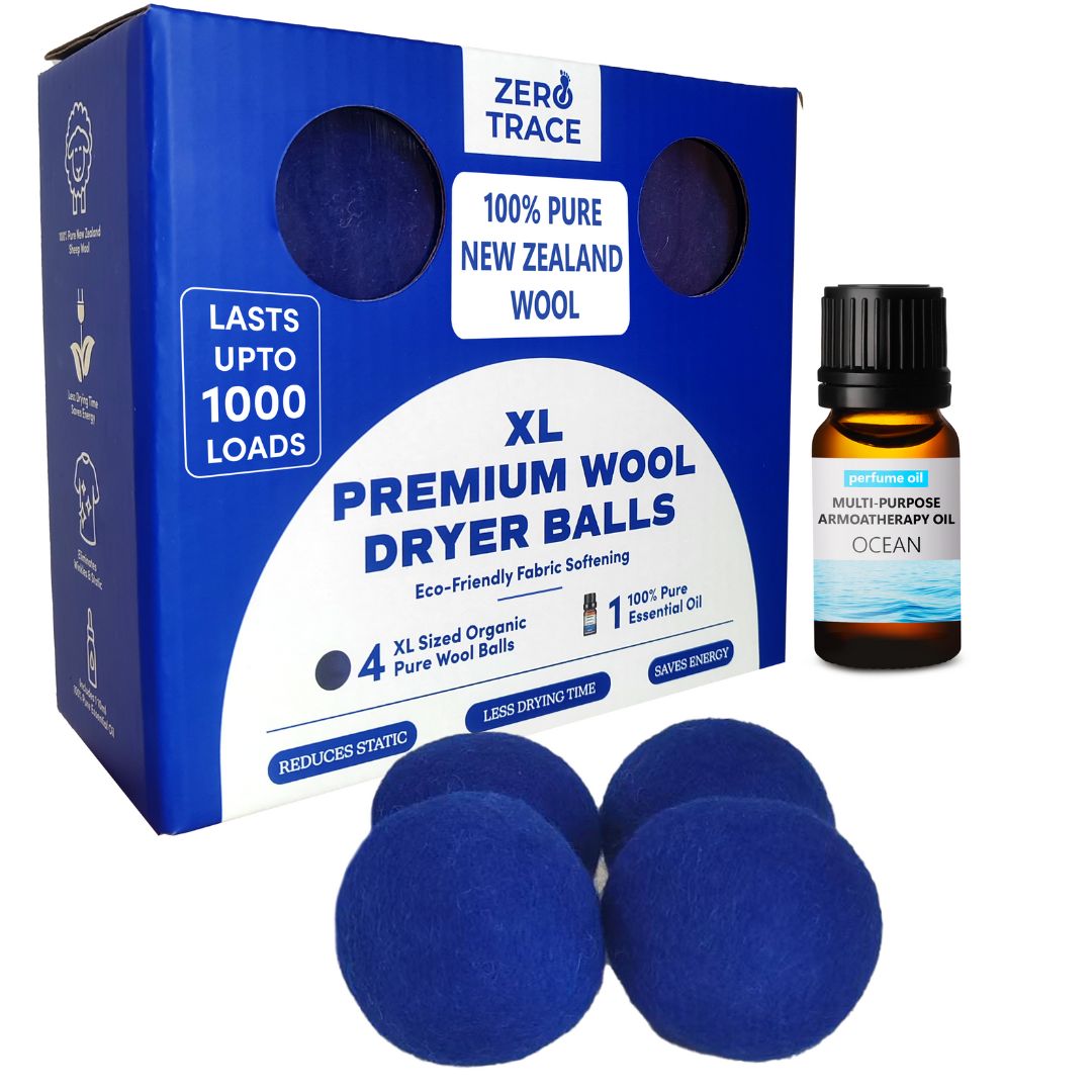 A box of Zero Trace Free Wool Dryer Balls with three blue balls in front and a bottle of "Ocean" multi-purpose aromatherapy oil beside it.
