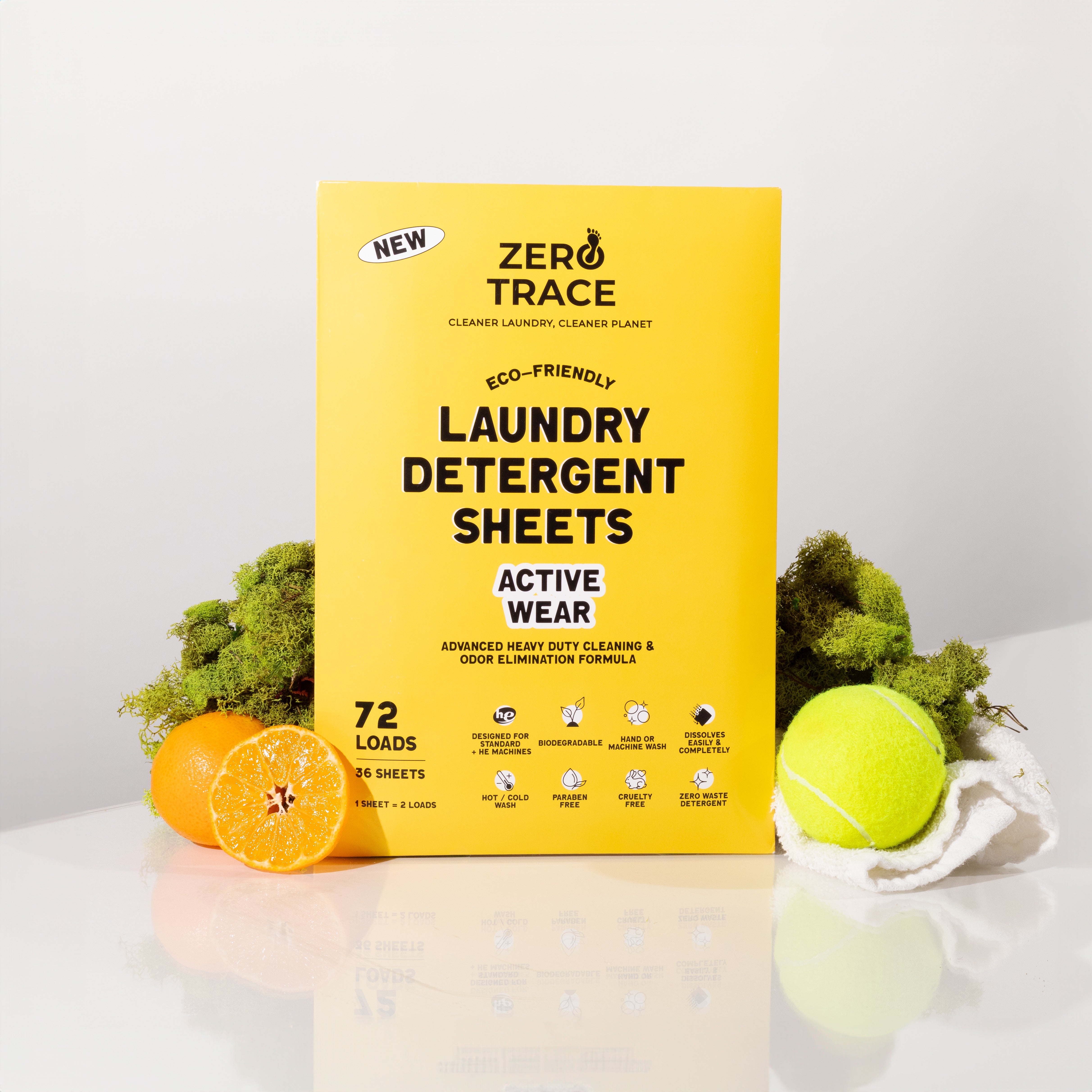 A Zero Trace safe box of Laundry Detergent Sheets placed adjacent to an orange and tennis ball.