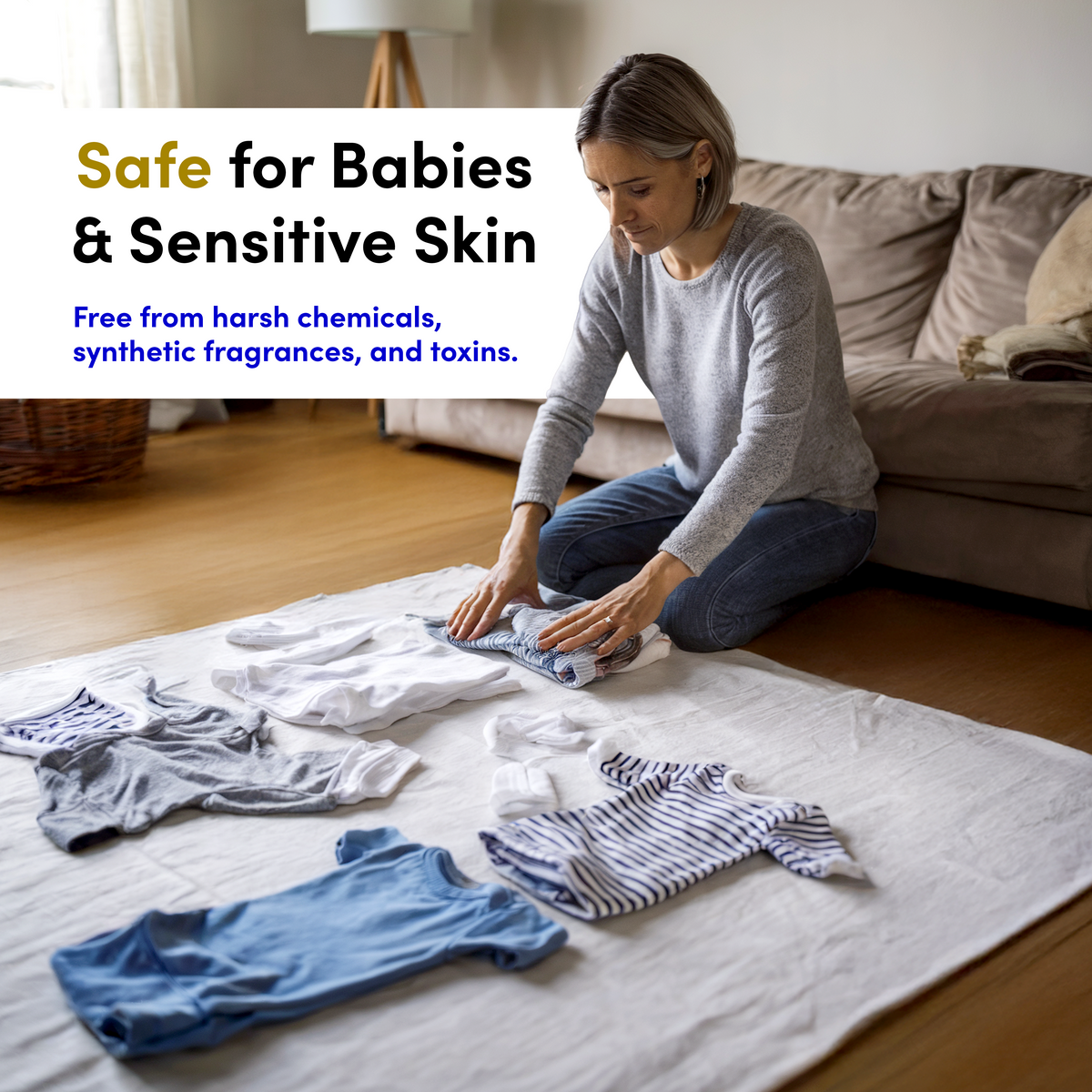 A woman kneels on the floor folding baby clothes on a white sheet, with text promoting safety for babies and sensitive skin. The scene highlights the use of Zero Trace Dryer Wool Balls made from New Zealand wool as a natural fabric softener, ensuring gentle care for delicate baby garments.